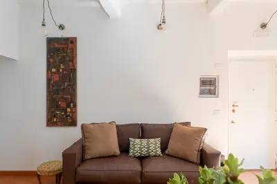 a living room with a brown couch against a white wall at iFlat Peaceful brand new 2beds apt in Trastevere in Rome