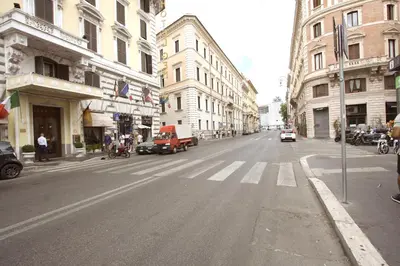 an empty city street with cars driving down a street at Navona New Charming Apartment in Rome