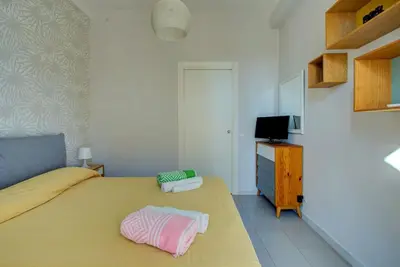 a bedroom with a yellow bed and a television at Casetta 79 in Rome