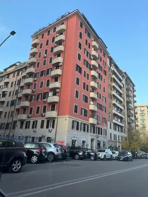 a red building with cars parked in a parking lot at Casetta 79 in Rome