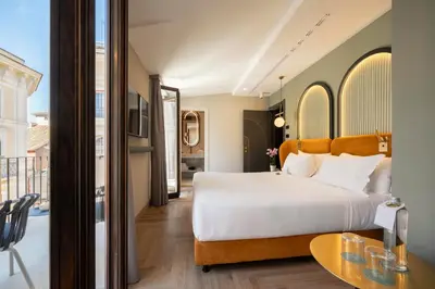 a bedroom with a large bed and a table at Je Rome Hotel in Rome
