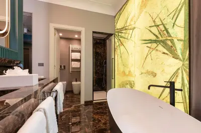 a bathroom with a large tub and sinks at Je Rome Hotel in Rome
