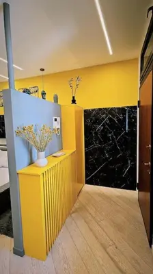 a room with a yellow wall and a vase with flowers in it at Trastevere golden luxury loft in Rome