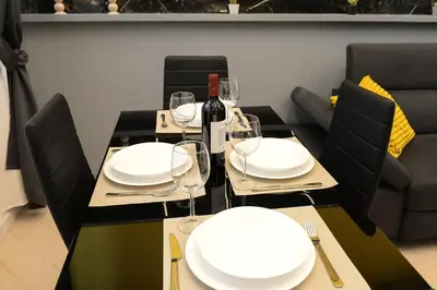 a table with white plates and wine glasses on it at Trastevere golden luxury loft in Rome