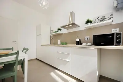 a kitchen with white cabinets and a microwave at Basilica San Paolo Nuvola EUR Modern apartment in Rome