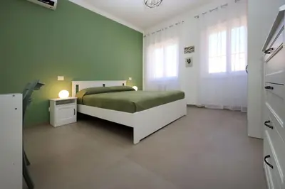 a bedroom with a bed and a green wall at Basilica San Paolo Nuvola EUR Modern apartment in Rome