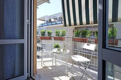 a balcony with a table and chairs on a balcony at Basilica San Paolo Nuvola EUR Modern apartment in Rome