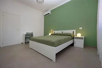 a bedroom with a bed and a green wall at Basilica San Paolo Nuvola EUR Modern apartment in Rome
