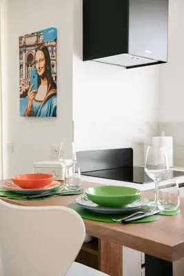 a kitchen with a table with plates and wine glasses at The Ciccins Apartment in Rome by Hostand in Rome