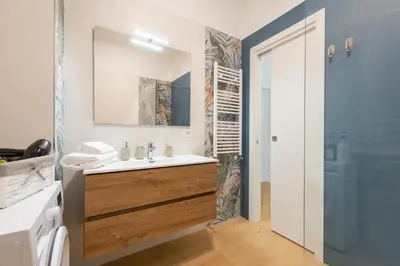 a bathroom with a sink and a toilet and a mirror at The Ciccins Apartment in Rome by Hostand in Rome