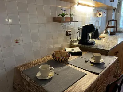 a table with cups and saucers on a kitchen counter at Accogliente Appartamento Roma in Rome