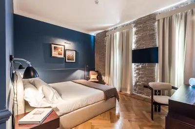 a bedroom with blue walls and a bed and a desk at The Fifteen Keys Hotel in Rome