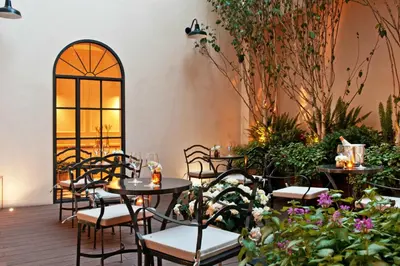 a patio with tables and chairs and plants at The Fifteen Keys Hotel in Rome