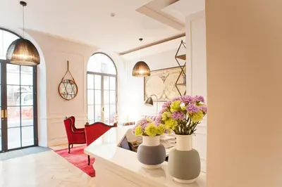 a living room with two vases with flowers on a table at The Fifteen Keys Hotel in Rome
