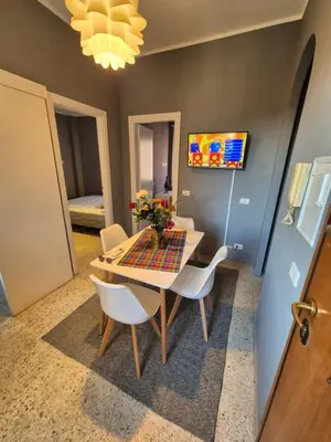 a dining room with a table and white chairs at Nice house in Roma Esquilino Colosseum in Rome