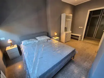 a bedroom with a blue bed with two lamps at Nice house in Roma Esquilino Colosseum in Rome