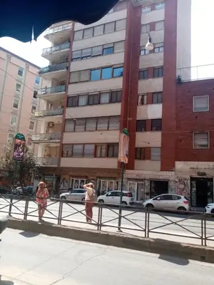 two people walking on a sidewalk in front of a building at Nice house in Roma Esquilino Colosseum in Rome