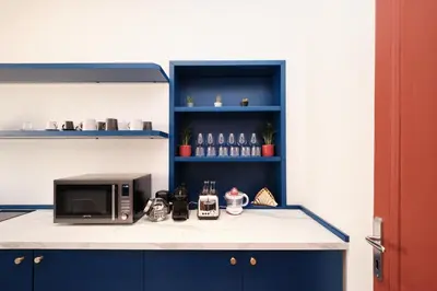 a kitchen with blue cabinets and a microwave on a counter at Elegant Apartment with view of Castel Sant'Angelo in Rome