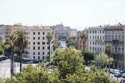 a view of a city with palm trees and buildings at Elegant Apartment with view of Castel Sant'Angelo in Rome
