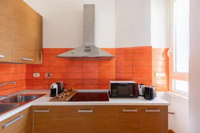 a kitchen with a stove top oven next to a sink at iFlat Bright & Comfy 2-Bedroom Apt near Vatican in Rome