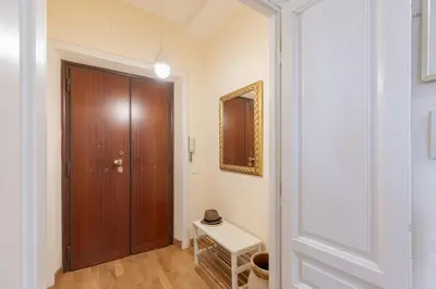 a hallway with a wooden door and a table at iFlat Bright & Comfy 2-Bedroom Apt near Vatican in Rome
