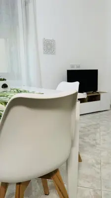 a white dining room table with a white chair at Home Fermi 80 in Rome