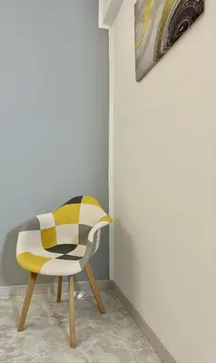 a yellow and white chair sitting next to a wall at Home Fermi 80 in Rome