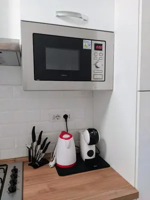a kitchen counter with a microwave above a stove at Home Fermi 80 in Rome