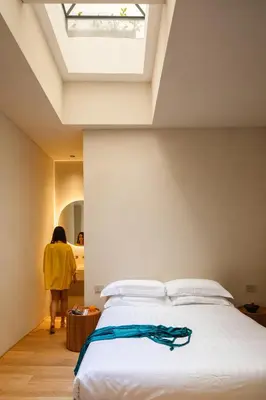 a woman standing in a bedroom with a bed at C10 Boutique Hotel in Rome
