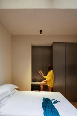 a woman sitting on a bed reading a book at C10 Boutique Hotel in Rome