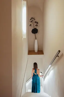 a woman in a blue dress walking down stairs at C10 Boutique Hotel in Rome