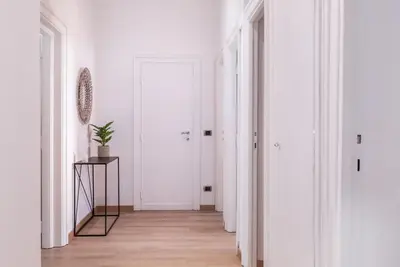 a hallway with white walls and a white door at Pinturicchio's Key in Rome