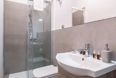 a bathroom with a sink and a shower and a toilet at Pinturicchio's Key in Rome