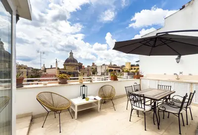 a balcony with a table and chairs and an umbrella at Monti Zen Penthouse-ZENO57 in Rome