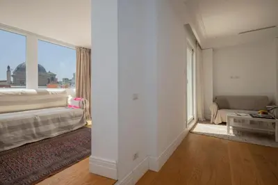 a living room with a couch and a large window at Monti Zen Penthouse-ZENO57 in Rome