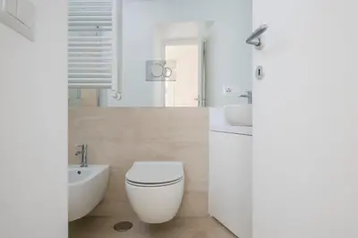a white bathroom with a toilet and a sink at Monti Zen Penthouse-ZENO57 in Rome