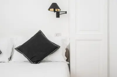 a black pillow sitting on top of a white bed at Monti Zen Penthouse-ZENO57 in Rome
