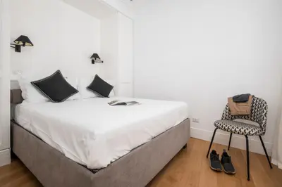a bedroom with a large bed and a chair at Monti Zen Penthouse-ZENO57 in Rome