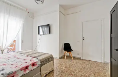 a bedroom with a bed and a black chair at Residenza Santa Barbara in Rome