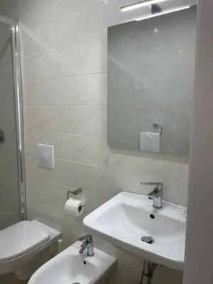 a white bathroom with a toilet and a mirror at Mille Guest house 2 in Rome