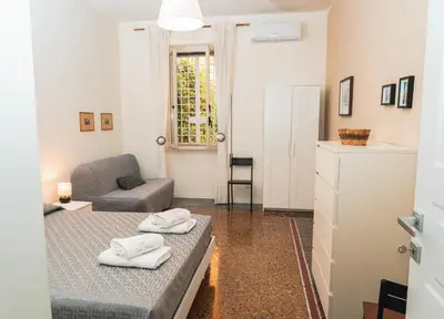 a living room with a bed and a chair at Il giardino di San Pietro - 10 minuti dai Musei Vaticani in Rome