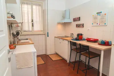 a small kitchen with a counter with stools in it at Il giardino di San Pietro - 10 minuti dai Musei Vaticani in Rome