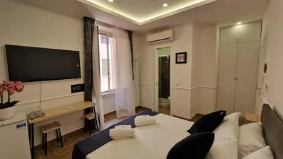 a living room with a white couch and a tv at Susy's Guest House - Room Colosseo in Rome