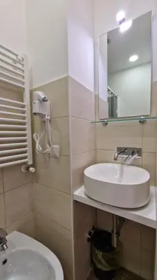 a bathroom with a white sink and a mirror at Susy's Guest House - Room Colosseo in Rome