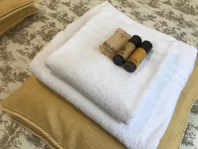 two bottles on a white towel on a table at House Maximo at Colosseum in Rome