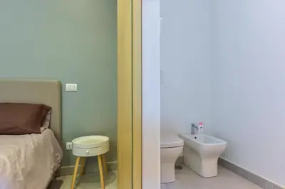 a bedroom with a bed and a toilet and a sink at Oasi Piceni Apartment San Lorenzo in Rome