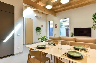 a dining room with a table and a couch at Oasi Piceni Apartment San Lorenzo in Rome
