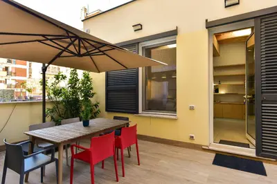 a table and chairs with an umbrella on a patio at Oasi Piceni Apartment San Lorenzo in Rome