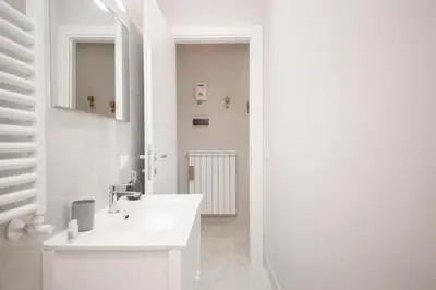 a white bathroom with a sink and a mirror at Rome Flat 42 by GHOR in Rome