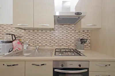 a kitchen with a sink and a stove at 4BNB - Cavalleggeri Apartment in Rome